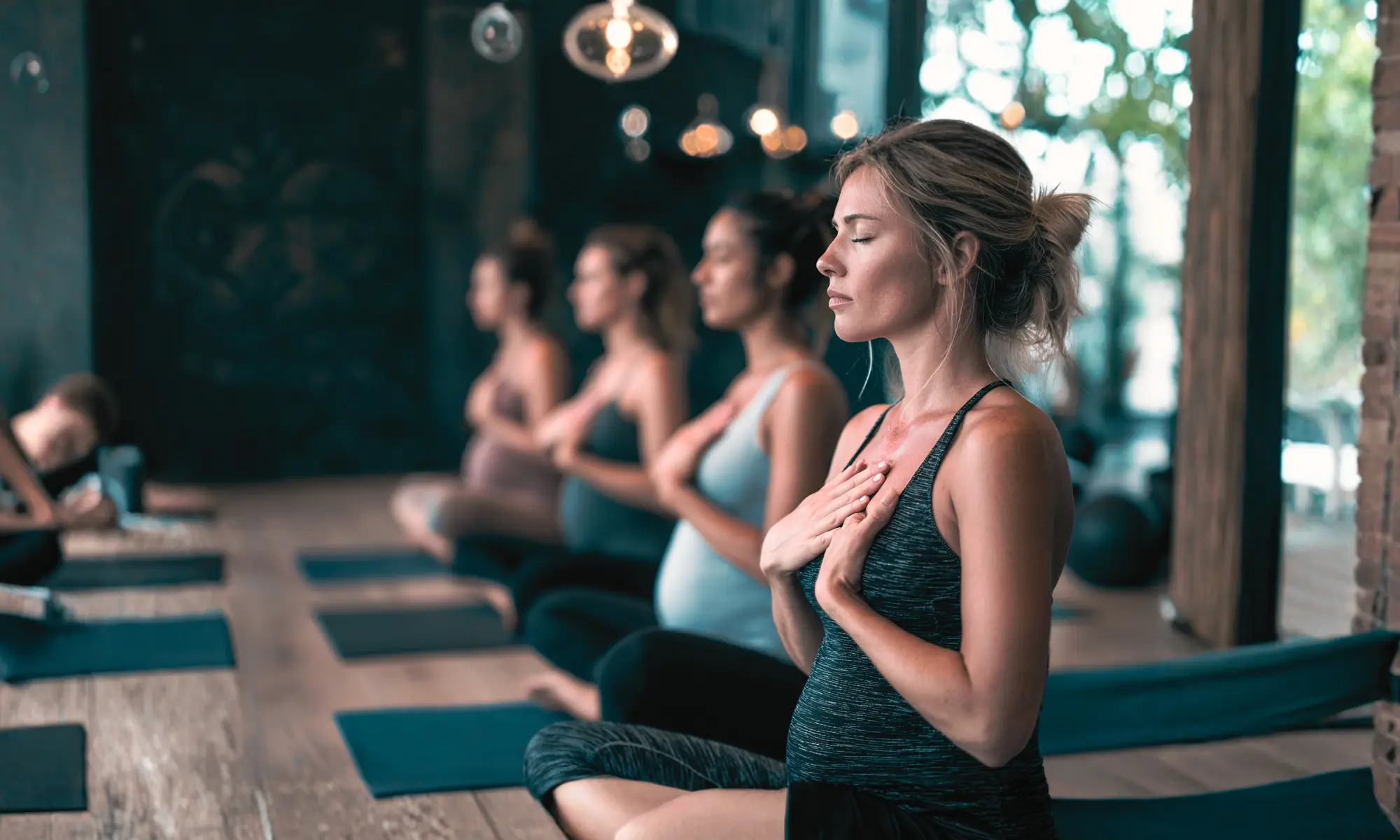 Group of people practicing mindfulness with hands on their chest in a studio