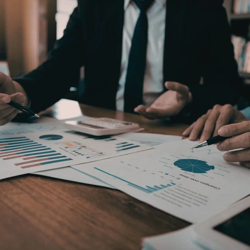Business professionals reviewing financial charts and documents at a table