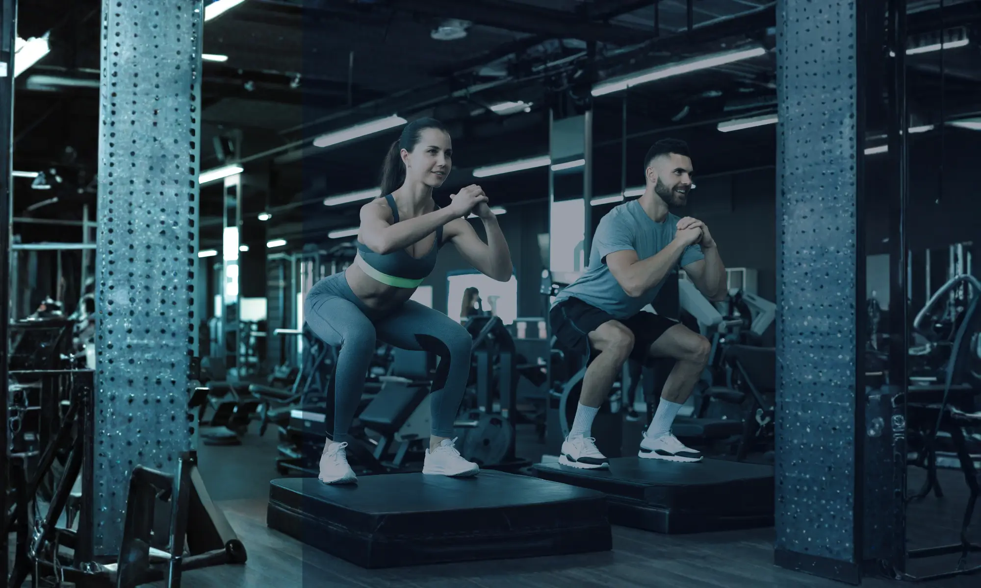 Two people performing squat exercises in a gym