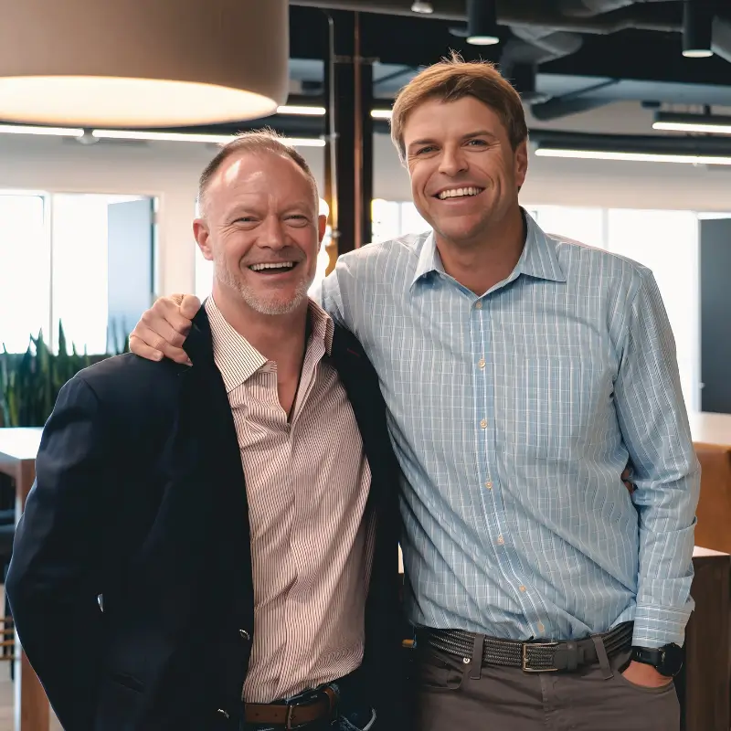 Travis Carson and Richard Schwartz standing together in a modern office setting